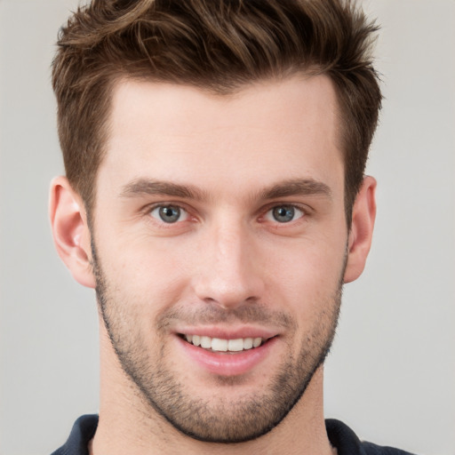 Joyful white young-adult male with short  brown hair and grey eyes