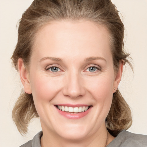 Joyful white young-adult female with medium  brown hair and grey eyes