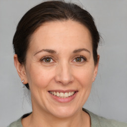 Joyful white adult female with medium  brown hair and grey eyes