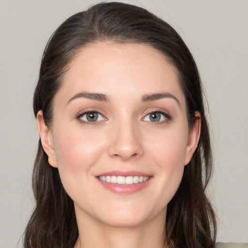 Joyful white young-adult female with long  brown hair and grey eyes