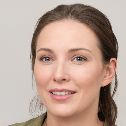 Joyful white young-adult female with medium  brown hair and grey eyes