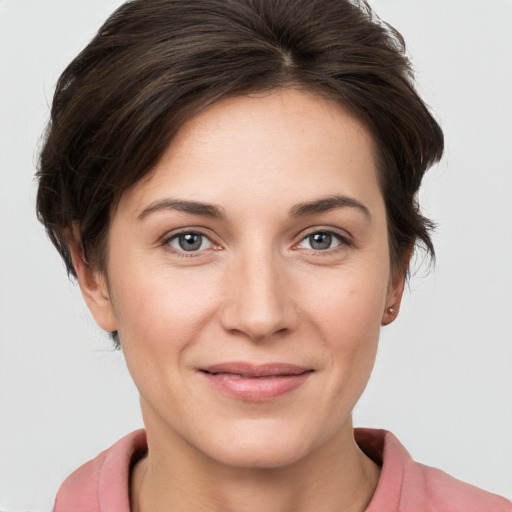 Joyful white young-adult female with short  brown hair and grey eyes