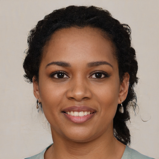 Joyful black young-adult female with short  black hair and brown eyes