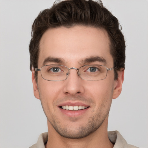 Joyful white young-adult male with short  brown hair and grey eyes