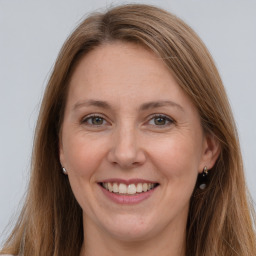 Joyful white adult female with long  brown hair and grey eyes