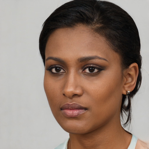Joyful black young-adult female with medium  brown hair and brown eyes