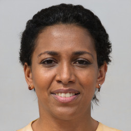 Joyful black adult female with short  brown hair and brown eyes