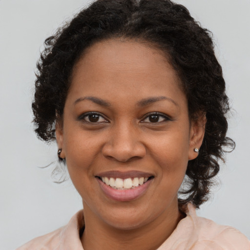 Joyful black young-adult female with medium  brown hair and brown eyes