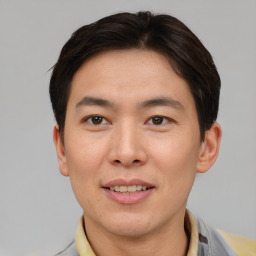Joyful asian young-adult male with short  brown hair and brown eyes
