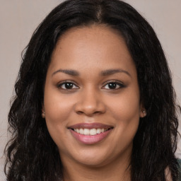 Joyful black young-adult female with long  brown hair and brown eyes