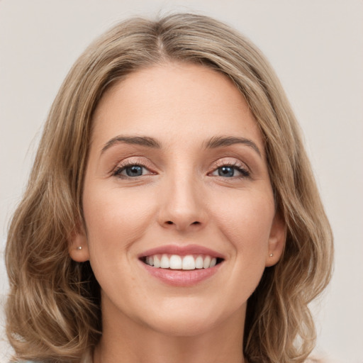 Joyful white young-adult female with long  brown hair and green eyes