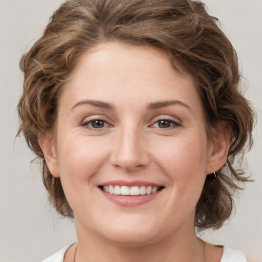 Joyful white young-adult female with medium  brown hair and green eyes