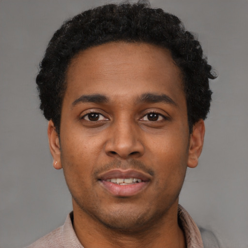 Joyful latino young-adult male with short  brown hair and brown eyes