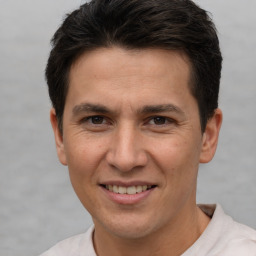 Joyful white adult male with short  brown hair and brown eyes