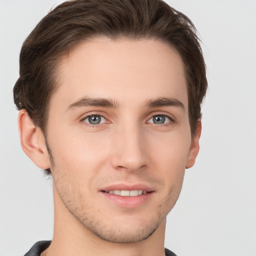 Joyful white young-adult male with short  brown hair and grey eyes