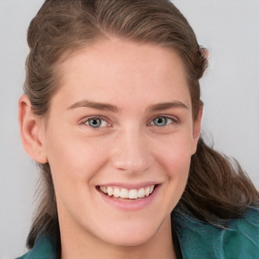 Joyful white young-adult female with long  brown hair and blue eyes