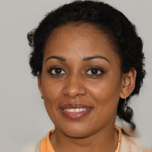 Joyful black young-adult female with short  brown hair and brown eyes