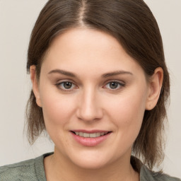 Joyful white young-adult female with medium  brown hair and grey eyes