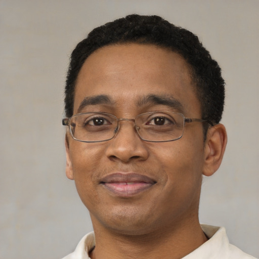 Joyful black adult male with short  black hair and brown eyes