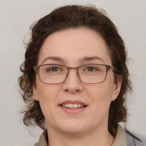 Joyful white adult female with medium  brown hair and green eyes