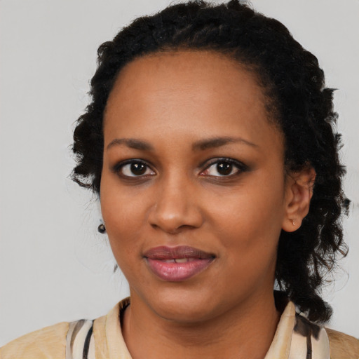 Joyful black young-adult female with long  black hair and brown eyes