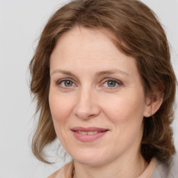 Joyful white adult female with medium  brown hair and grey eyes