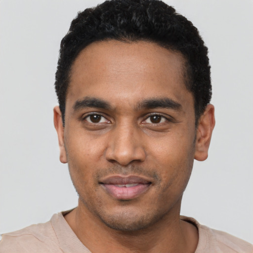 Joyful black young-adult male with short  black hair and brown eyes