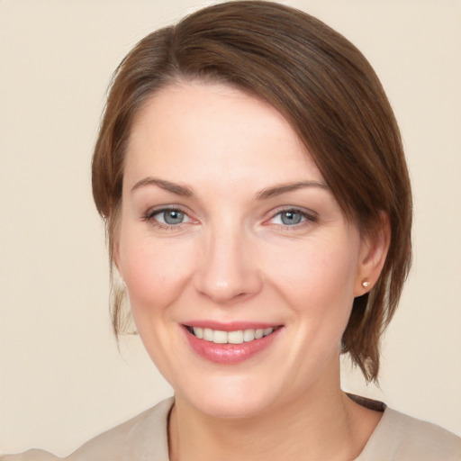 Joyful white young-adult female with medium  brown hair and blue eyes