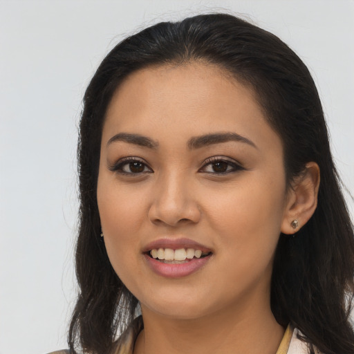Joyful latino young-adult female with long  brown hair and brown eyes