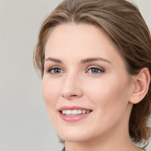 Joyful white young-adult female with medium  brown hair and blue eyes