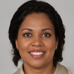 Joyful black adult female with medium  brown hair and brown eyes