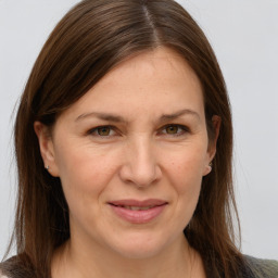 Joyful white adult female with long  brown hair and grey eyes