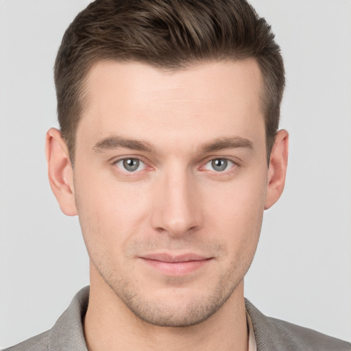 Joyful white young-adult male with short  brown hair and grey eyes