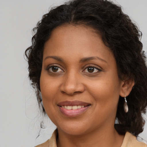 Joyful black young-adult female with long  brown hair and brown eyes