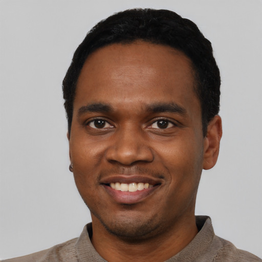 Joyful black young-adult male with short  black hair and brown eyes