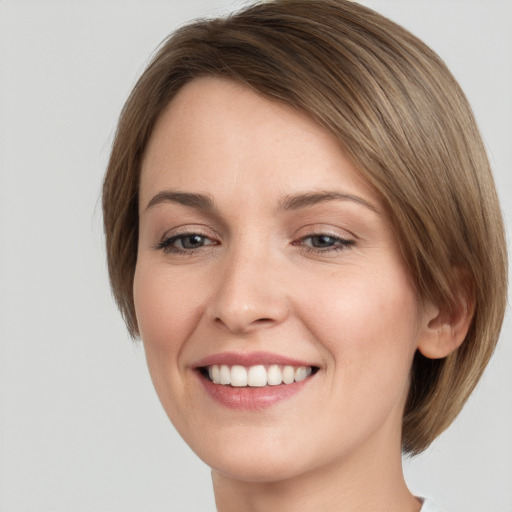 Joyful white young-adult female with medium  brown hair and grey eyes