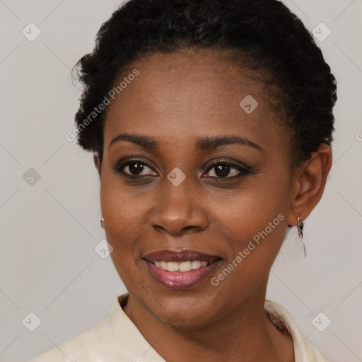 Joyful black young-adult female with short  black hair and brown eyes