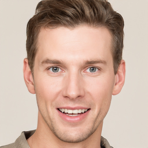 Joyful white young-adult male with short  brown hair and grey eyes