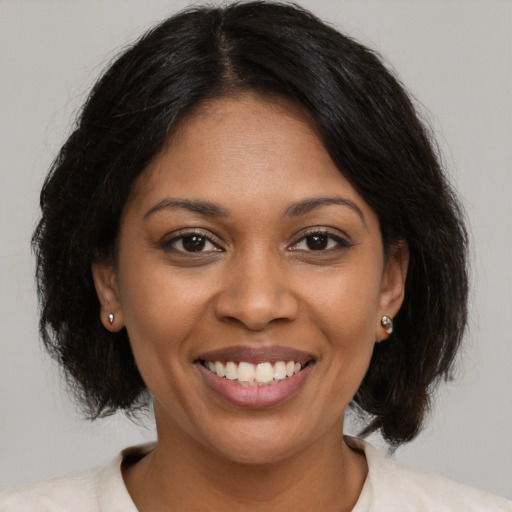 Joyful black young-adult female with medium  brown hair and brown eyes