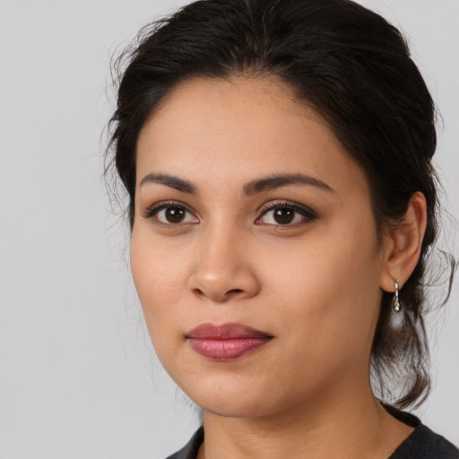 Joyful latino young-adult female with medium  brown hair and brown eyes