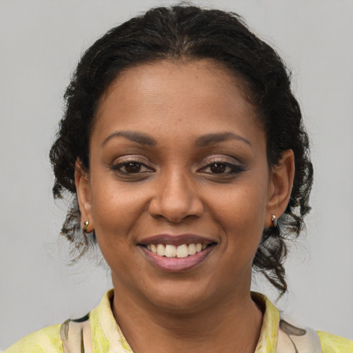 Joyful black young-adult female with short  brown hair and brown eyes