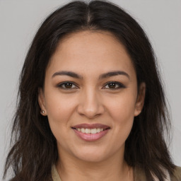 Joyful latino young-adult female with long  brown hair and brown eyes