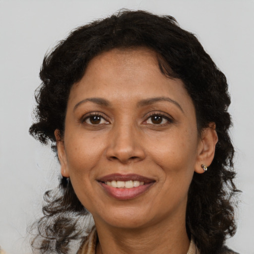 Joyful black adult female with medium  brown hair and brown eyes