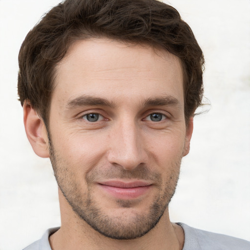 Joyful white young-adult male with short  brown hair and grey eyes