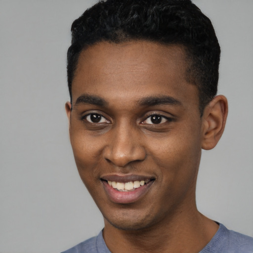 Joyful black young-adult male with short  black hair and brown eyes