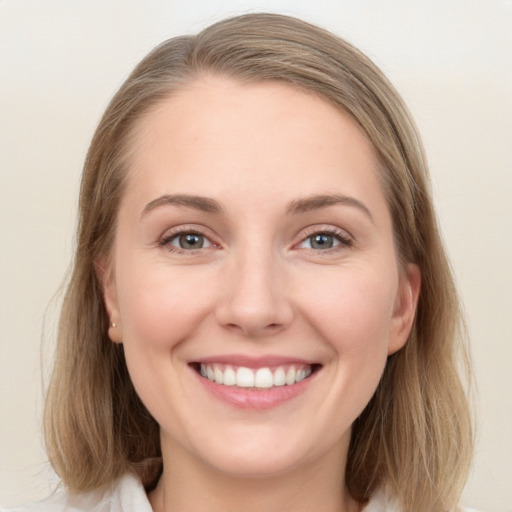 Joyful white young-adult female with medium  brown hair and blue eyes