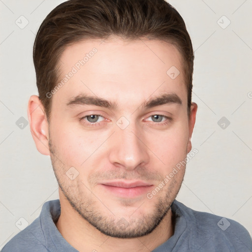 Joyful white young-adult male with short  brown hair and grey eyes