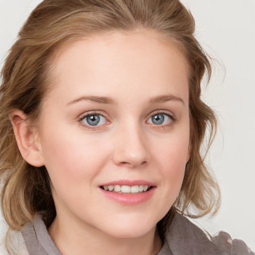 Joyful white young-adult female with medium  brown hair and blue eyes