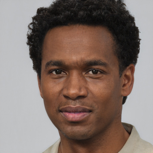 Joyful black young-adult male with short  black hair and brown eyes