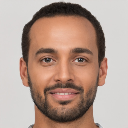 Joyful latino young-adult male with short  black hair and brown eyes